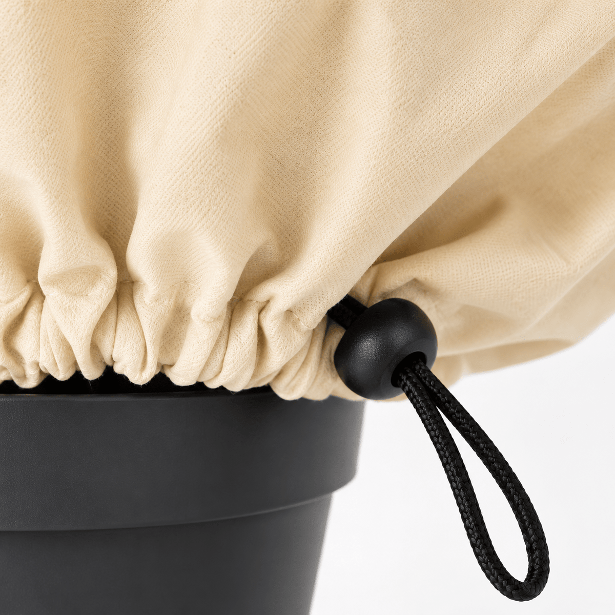Zwart trekkoord met koordstopper aan de onderzijde van de beige plantenhoes